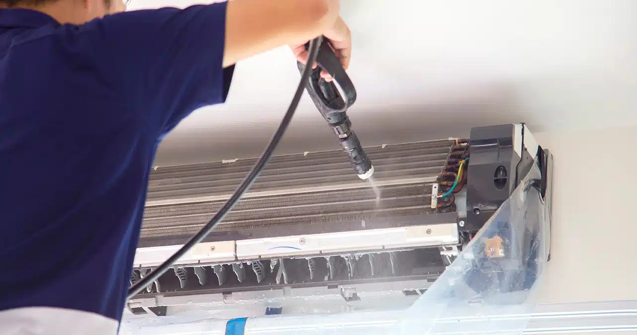 An AC Technician in Cleaning The Air Conditioner