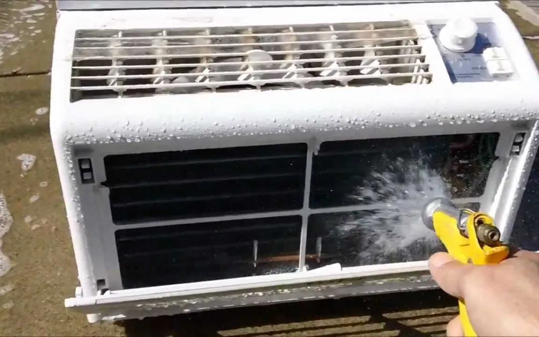 An AC Technician is cleaning the window AC