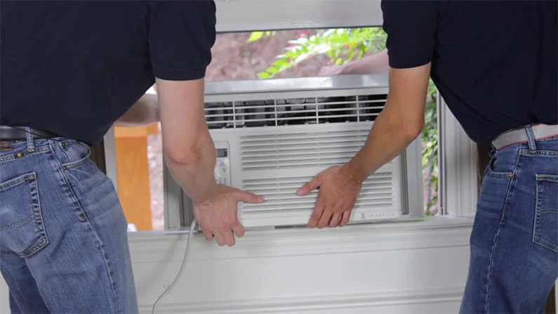 AC Technicians are installaing the Window Ac on the window