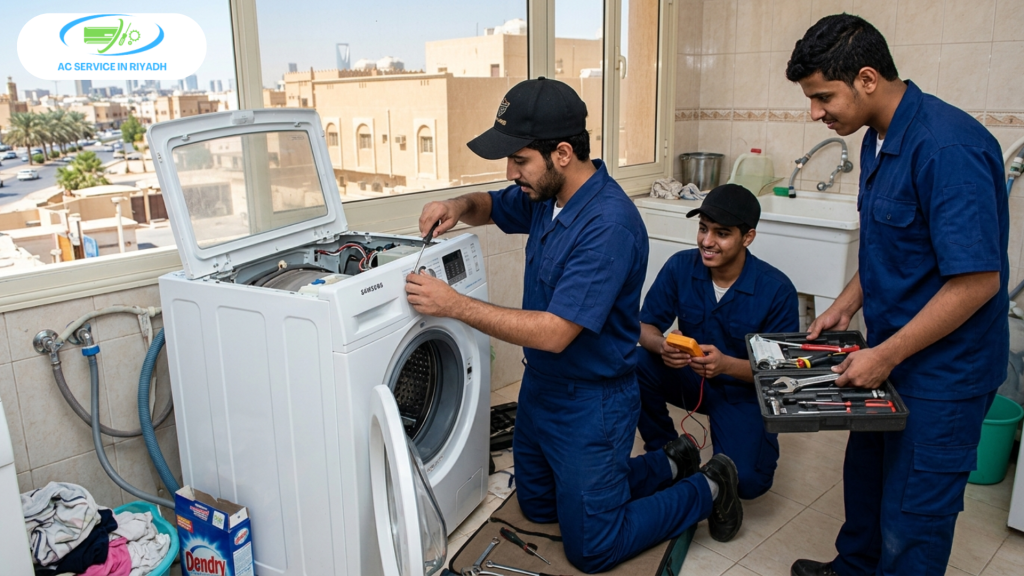 Team of young men in blue uniforms and black caps repairing an automatic washing machine in a Riyadh home.